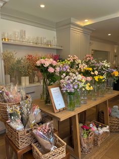 a table filled with lots of flowers on top of a hard wood floored floor