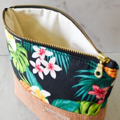 Bright pops of plumerias, pineapples, and tropical leaves decorate these Hawaiian print bags. Half Hawaiian print and half solid, these bags are the perfect size for all your essentials! Due to the handmade nature and pattern, no two purses are the same. Product Details Cotton, linen cotton 8.25" wide x 5.5" tall x 2.5" deep Interfaced for stability and structure Metal YKK zipper Care Instructions Spot clean recommended. Hand wash cold as needed. Keep bag looking fresh with a high-heat iron and Natural Color Tropical Beach Bag, Tropical Style Beach Bag For Daily Use, Tropical Rectangular Beach Bag, Handmade Makeup, Hawaiian Print, Ykk Zipper, Makeup Pouch, Bag Handmade, Printed Bags