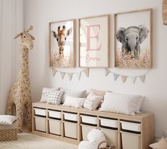 a baby's room with two giraffes and three framed pictures on the wall