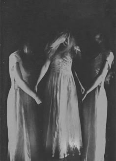 three women in long dresses standing next to each other