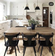 a kitchen with white cabinets and black chairs is pictured in this image, there are several lights hanging from the ceiling