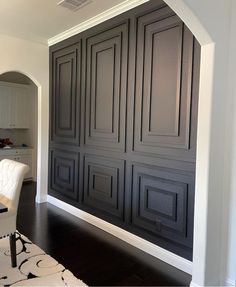 a living room with white furniture and black paneling on the walls, along with an area rug