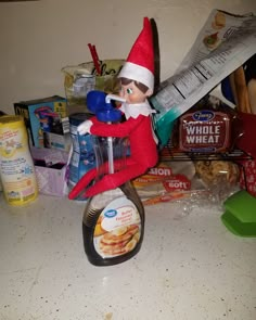 an elf is sitting on top of a blender with food in front of him