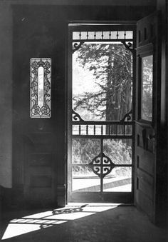 an open door leading into a room with a large window and iron bars on the doors