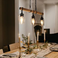 a wooden table topped with plates and candles