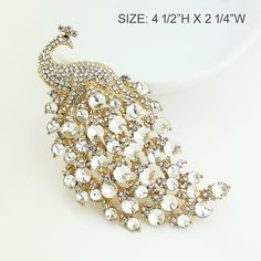 "Gorgeous large rhinestone peacock brooch jewelry embellishment, which can be used for your DIY project - peacock theme wedding bridal brooch bouquet, ring pillow, invitations, cake decorations, event decor, crafts, scrap booking, jewelry gift and much more! Perfect for peacock theme wedding! Size: 4 1/4\"H x 2 1/4\"W Stones: Clear crystal Metal color: Gold plated This crystal bird broach can be ordered with pin in the back to add to wedding gown or dress sash, to wire into brooch bouquet, or an Wedding Brooch With Peacock Design, Elegant Peacock-colored Brooches For Wedding, Elegant Peacock Brooches For Wedding, Elegant Wedding Brooch With Peacock Design, Elegant Peacock Design Brooch For Wedding, Elegant Peacock Color Wedding Brooches, Elegant Peacock Design Wedding Brooch, Peacock Colored Wedding Brooch Jewelry, Elegant Party Brooch With Peacock Design