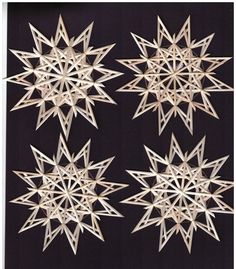 four white snowflakes hanging on a black wall