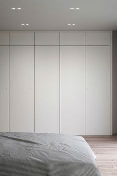 an empty bedroom with white closets and a large bed in the middle of it