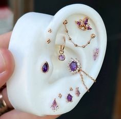 a person holding an ear with jewelry on it