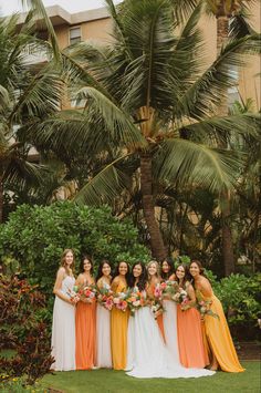 a group of women standing next to each other on top of a lush green field