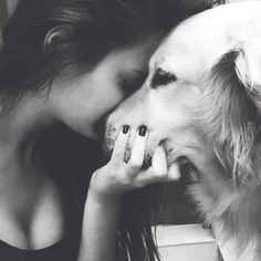 a woman kissing her dog on the nose