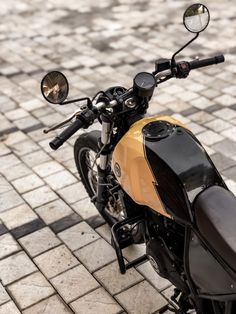 a motorcycle parked on top of a brick road