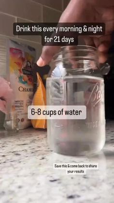 someone is pouring water into a glass jar