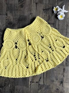 a yellow crocheted skirt with holes on the bottom and black dots at the bottom