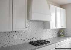 a kitchen with white cabinets and granite counter tops, along with a stove top oven