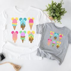 Bring some magic to your summer wardrobe with this enchanting ice cream tshirt! The colorful design features magical ice cream treats, perfect for any Orlando theme park vacation or family trip. Made with soft and breathable fabric, this v neck tshirt is both comfortable and stylish.This classic unisex jersey short sleeve tee fits like a well-loved favorite. Soft cotton and quality print make users fall in love with it over and over again.  These t-shirts have-ribbed knit collars to bolster shaping. The shoulders have taping for better fit over time. Dual side seams hold the garment's shape for longer.  .: 100% Airlume combed and ringspun cotton (fiber content may vary for different colors) .: Light fabric (4.2 oz/yd² (142 g/m .: Retail fit .: Tear away label .: Runs true to size NOTE: Chi Summer Multicolor Character Print T-shirt, Family Matching Cartoon Print T-shirt For Summer, Playful Summer T-shirt For Gift, Playful Summer T-shirt Gift, Playful Summer T-shirt As A Gift, Playful Summer T-shirt As Gift, Summer Graphic Print Matching T-shirt, Summer T-shirt With Cartoon Print For Gift, Fun Multicolor T-shirt For Gift