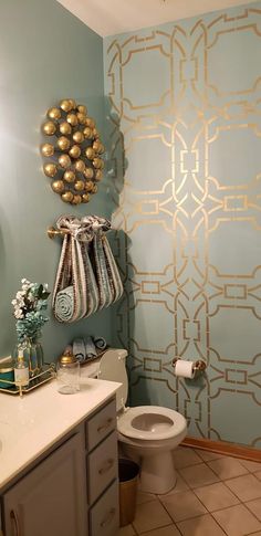 a bathroom with blue walls and gold accents