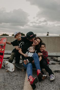 a family sitting on the ground with their skateboards