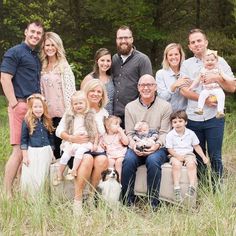 an image of a family posing for a photo in front of some trees and grass