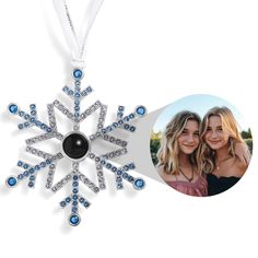 an ornament with two women and a snowflake hanging from it's side