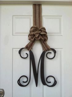 a monogrammed door hanger with a bow on it's front door