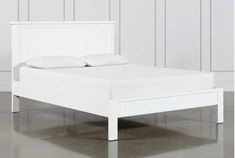 a white bed sitting on top of a hard wood floor