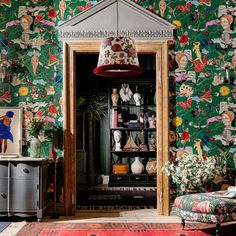 a living room filled with furniture and colorful wallpaper