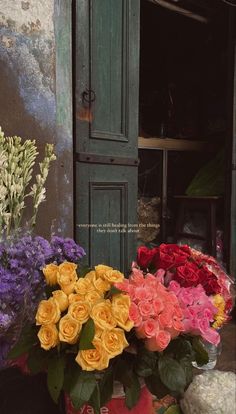 a bunch of flowers that are sitting in front of a door