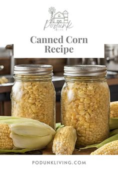 two jars filled with corn sitting on top of a table next to an ear of corn