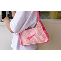 a woman is holding a pink purse in her hands