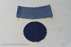 two pieces of blue fabric are next to each other on a white surface with yellow tape