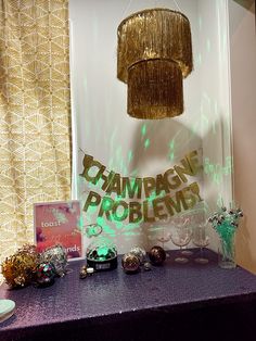 a purple table topped with lots of items and a chandelier hanging from the ceiling