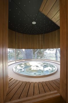 an indoor hot tub in the middle of a room with wooden walls and flooring