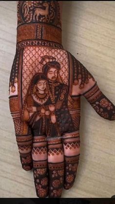 the hand is decorated with henna and an image of a man holding a woman