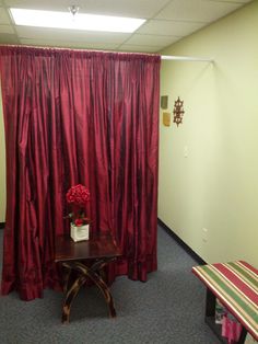 a room with red curtains and a small table