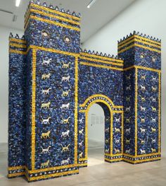 an art installation made out of blue and yellow tiles with cats on it's walls