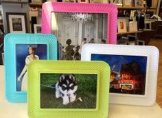 four different colored frames on a table with pictures in the middle and one has a black and white dog