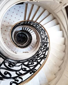 a spiral staircase with wrought iron railings