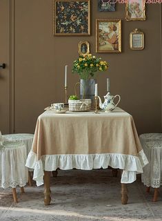 a dining room table with two chairs and pictures on the wall