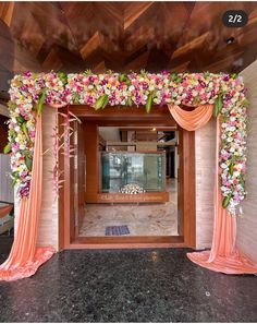 an entrance decorated with flowers and draping for a wedding or special event venue