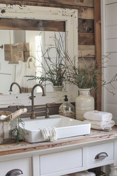 a white sink sitting under a bathroom mirror next to a wooden counter top with dishes on it