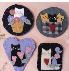 four felt heart shaped magnets with cats and flowers in them on a pink background