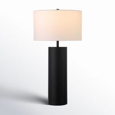 a black table lamp with a white shade on the base and a light in the middle