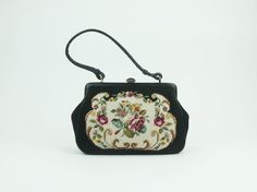 Very pretty little handbag from the 1950s. Multi-color floral pattern in petit point gobelin embroidery (wool) on black. Black leather details and handle. Brass snap closure. Lining black leather and black fabric. 2 inside pockets. Very good condition. Dimensions:  Width 9.84" (25 cm) bottom to 8.66" (22 cm) top, height 7.08" (18 cm), depth 2.36" (6 cm), weight 350 gms. Refunds and Exchanges (for customers outside the European Union): All sales are final. You will not be refunded if an item does Tapestry Embroidery, Embroidery Bags, Top Handle Bags, Vintage Postcards, Black Fabric, Needlepoint, Inside Pocket, Purses And Handbags, Floral Pattern