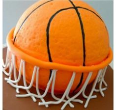 an orange basketball cake with white icing on top