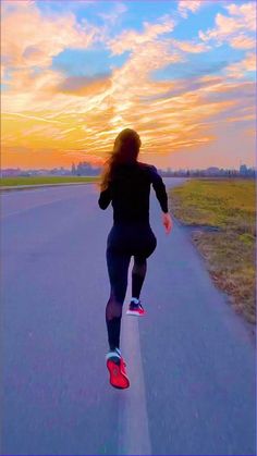 a woman running down the road at sunset