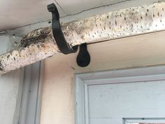 a close up of a piece of wood hanging from a ceiling with a hook on it