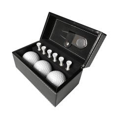 four golf balls in a black box with white trimmings on the top and two putter's backs