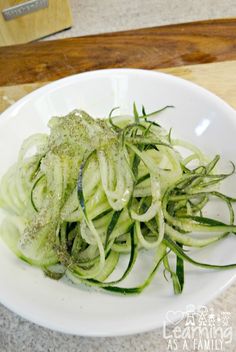 a white plate topped with sliced cucumbers on top of a counter