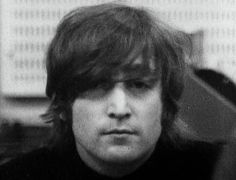 black and white photograph of a man with long hair wearing a turtle neck sweater looking at the camera